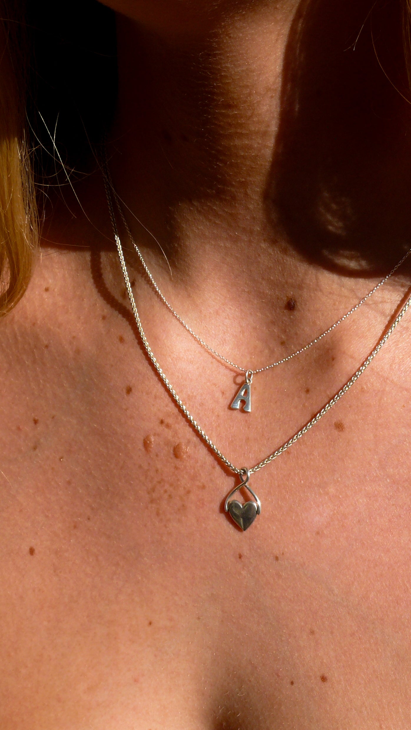 Silver Spinning Heart Necklace and Initial Charms on model