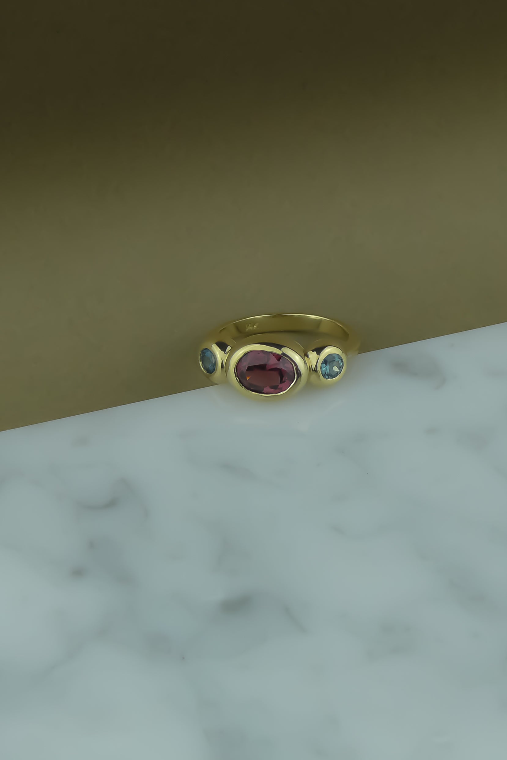 custom gold foundation trio ring with garnet and teal sapphires