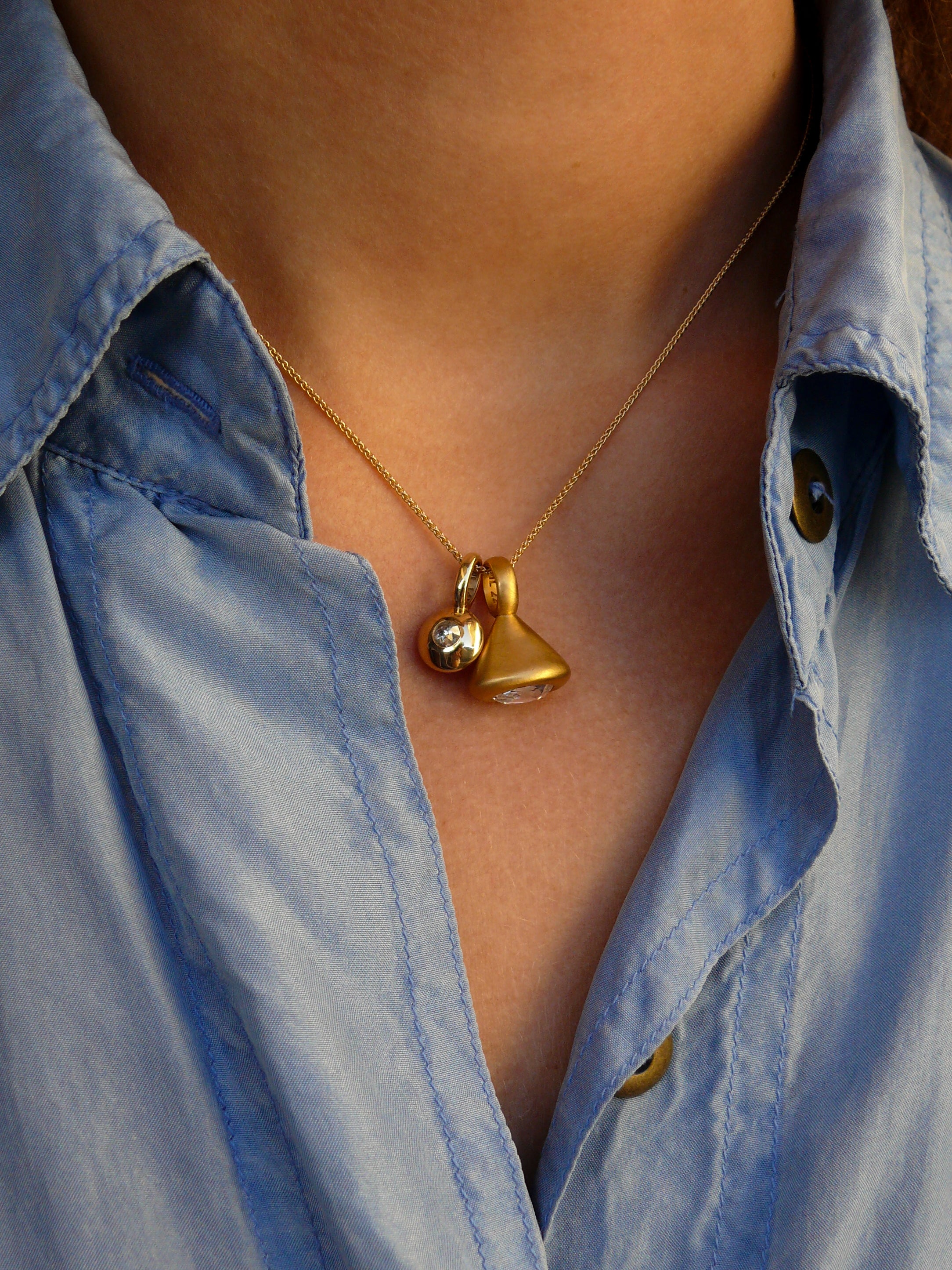 Gold-sapphire-diamond-reflection-oval-diamond-pendulum-charm-on model
