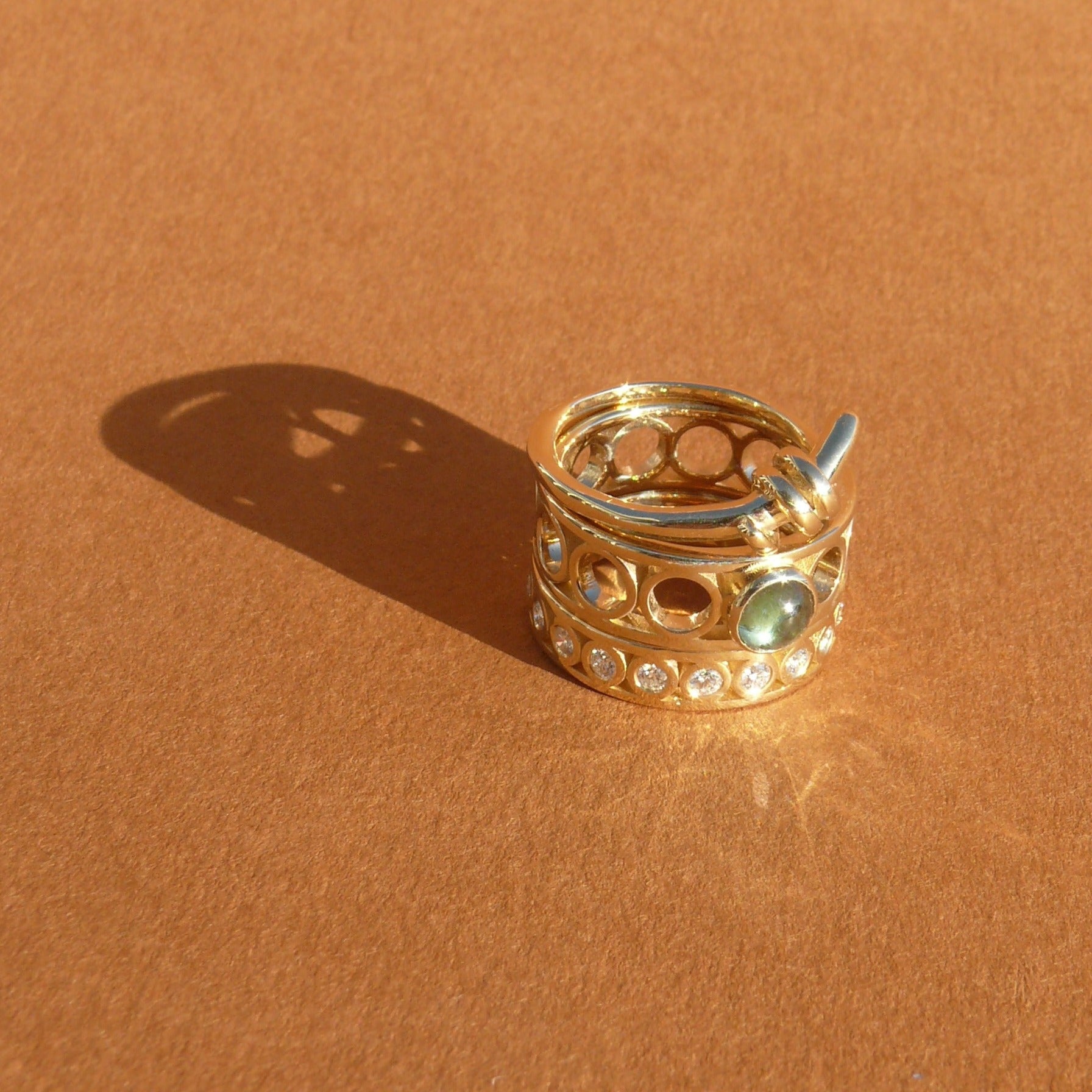 Teal Australian Sapphire set atop a wide ring band made of 14k recycled yellow gold