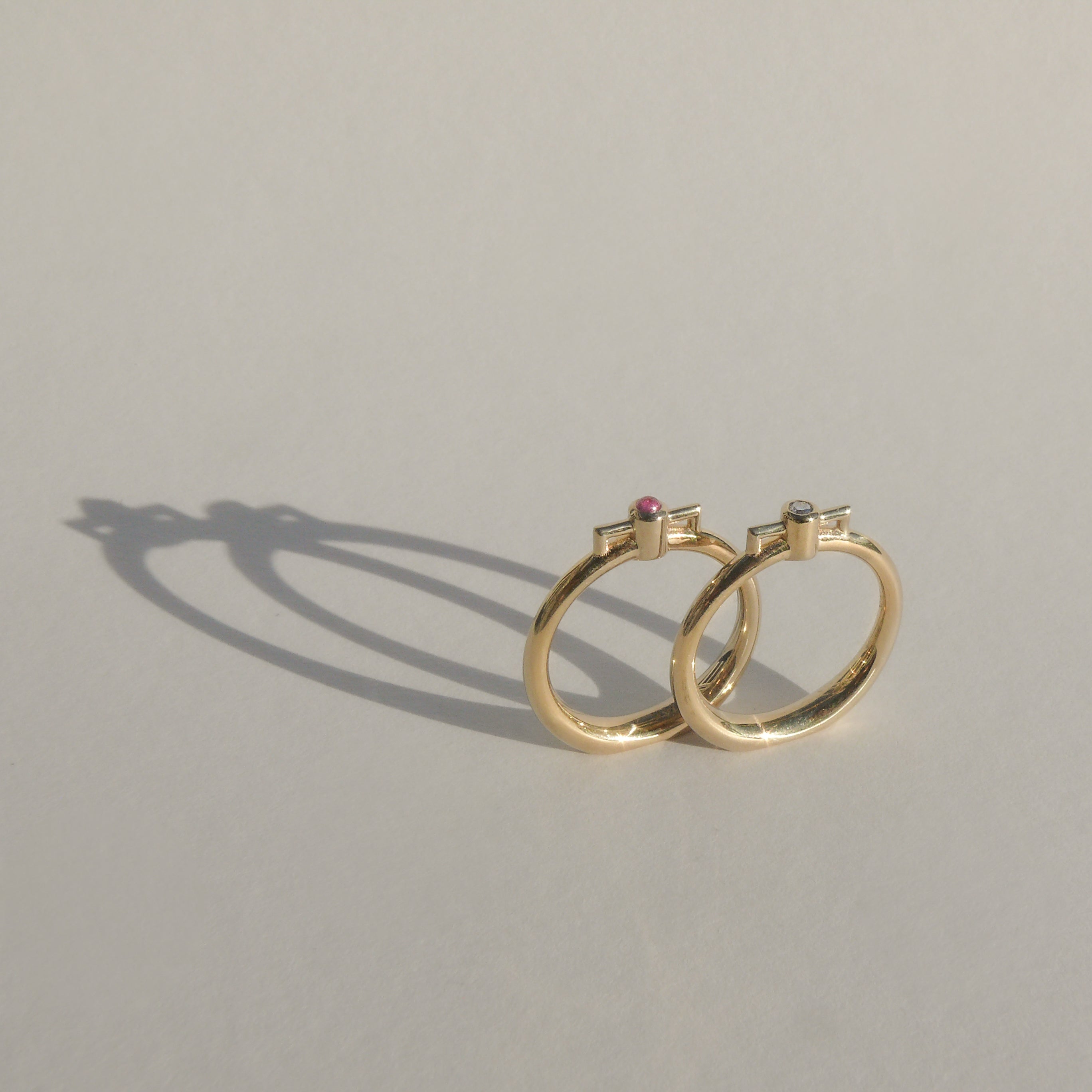2mm recycled white diamond bezel set atop a 14k recycled yellow gold ring band with a silhouette of a vessel with square handles