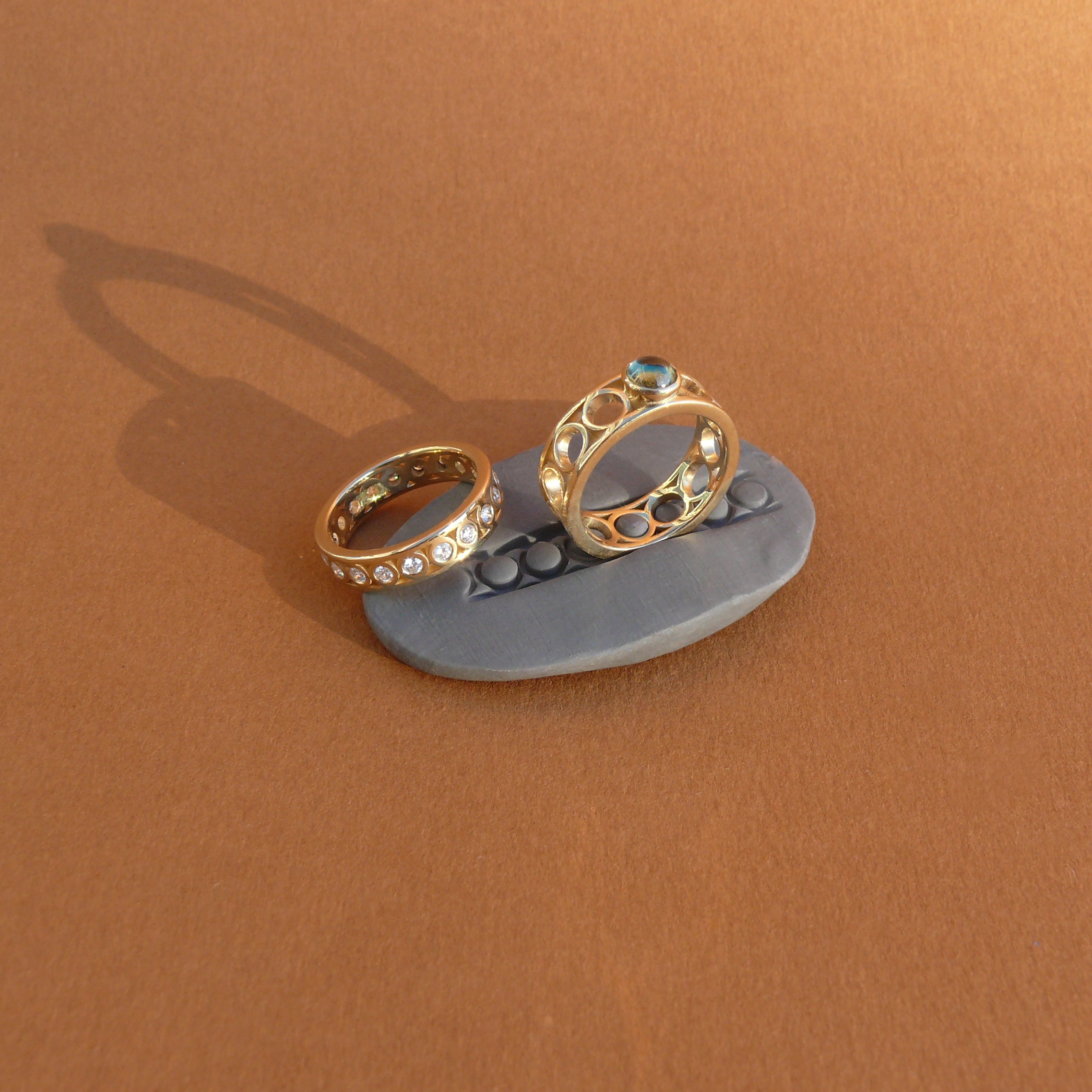 Teal Australian Sapphire set atop a wide ring band made of 14k recycled yellow gold