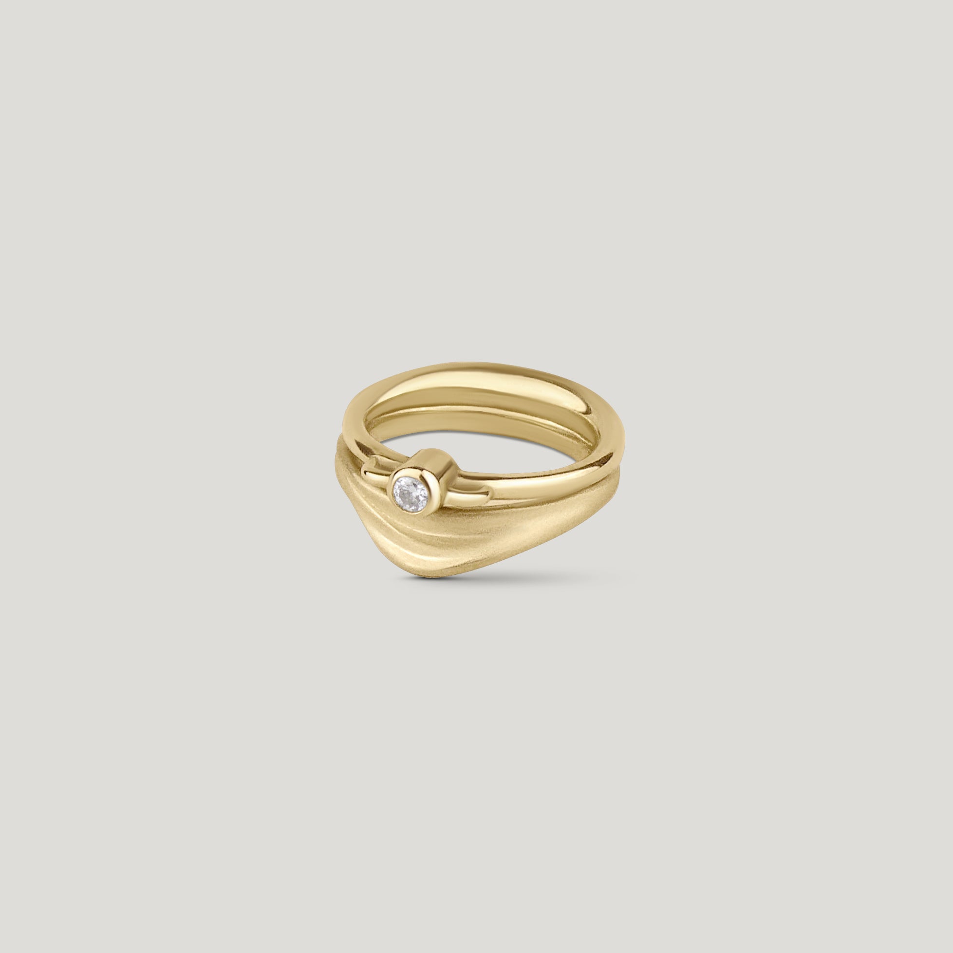Curved dune gold wedding ring with organic texture stacked with diamond solitaire vessel ring