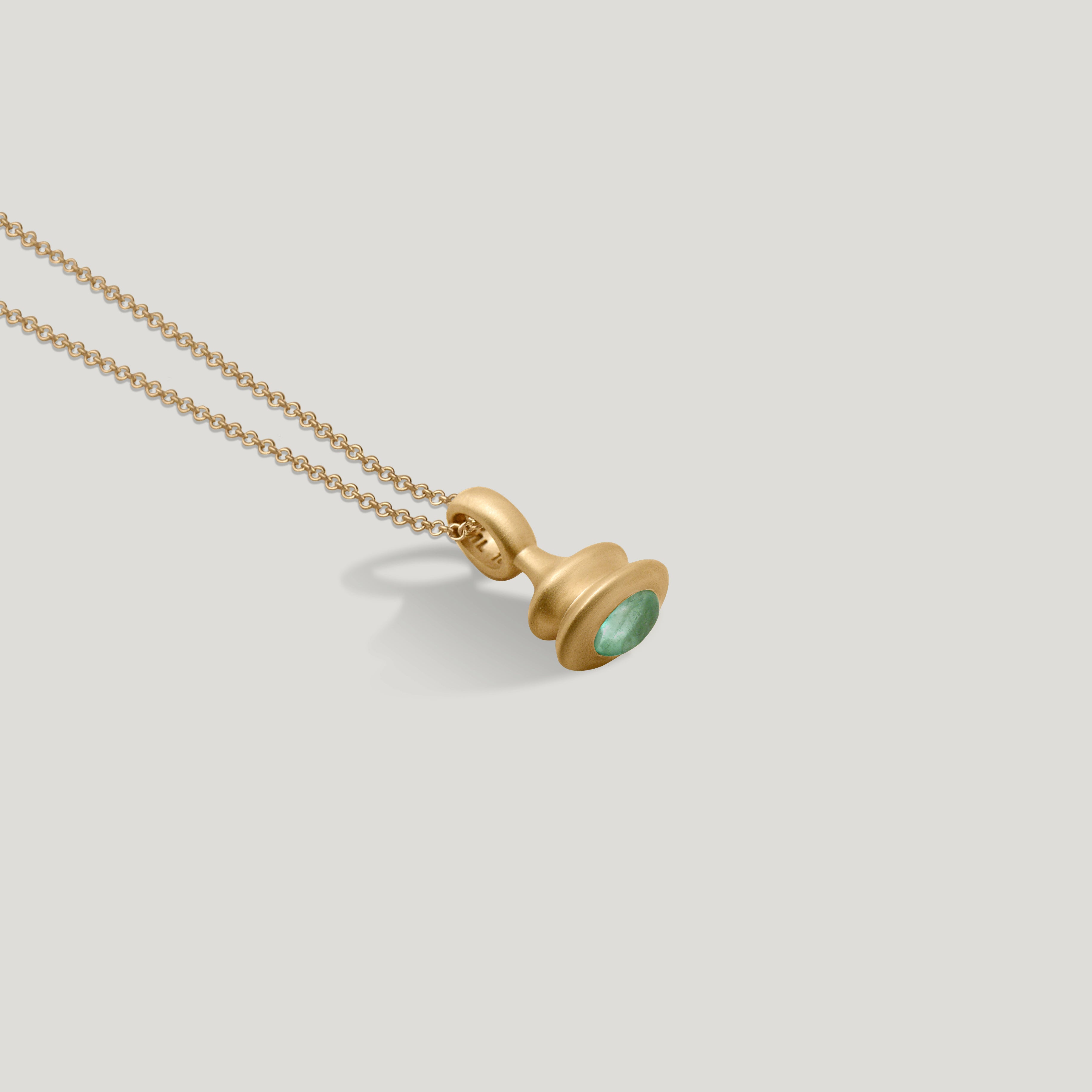 Gold pendulum charm with a green beryl on a 1.5mm cable chain on a light gray background