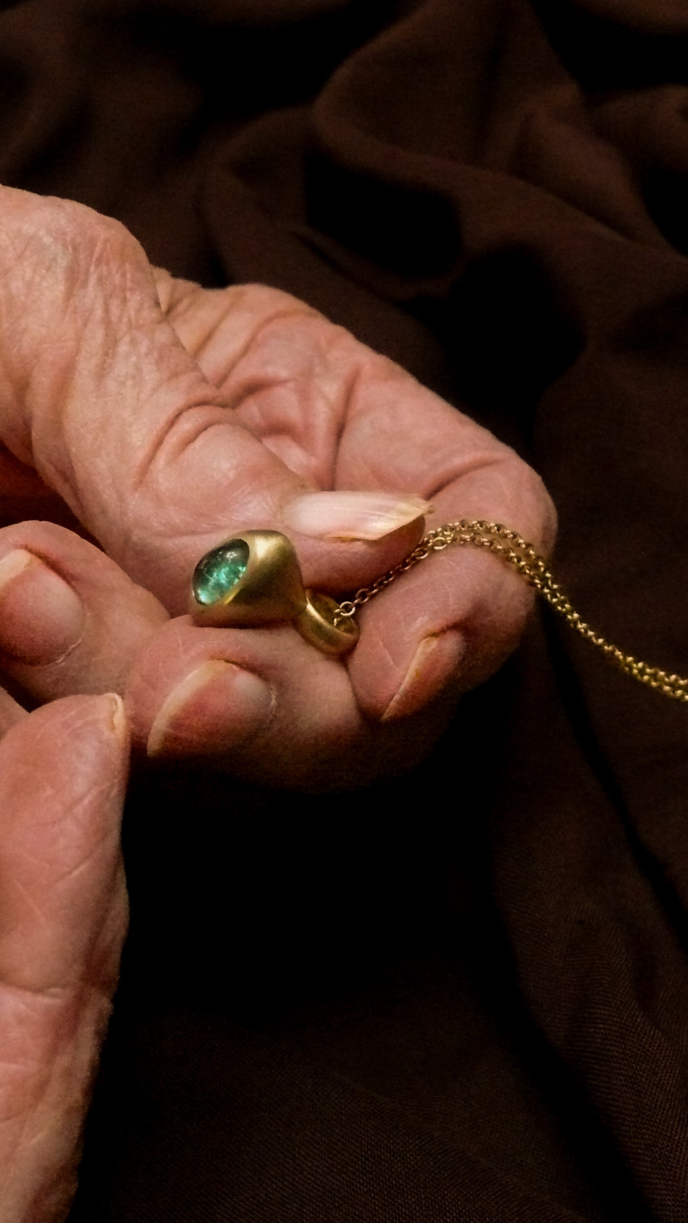 Teal tourmaline pendulum charm in grandma's hands