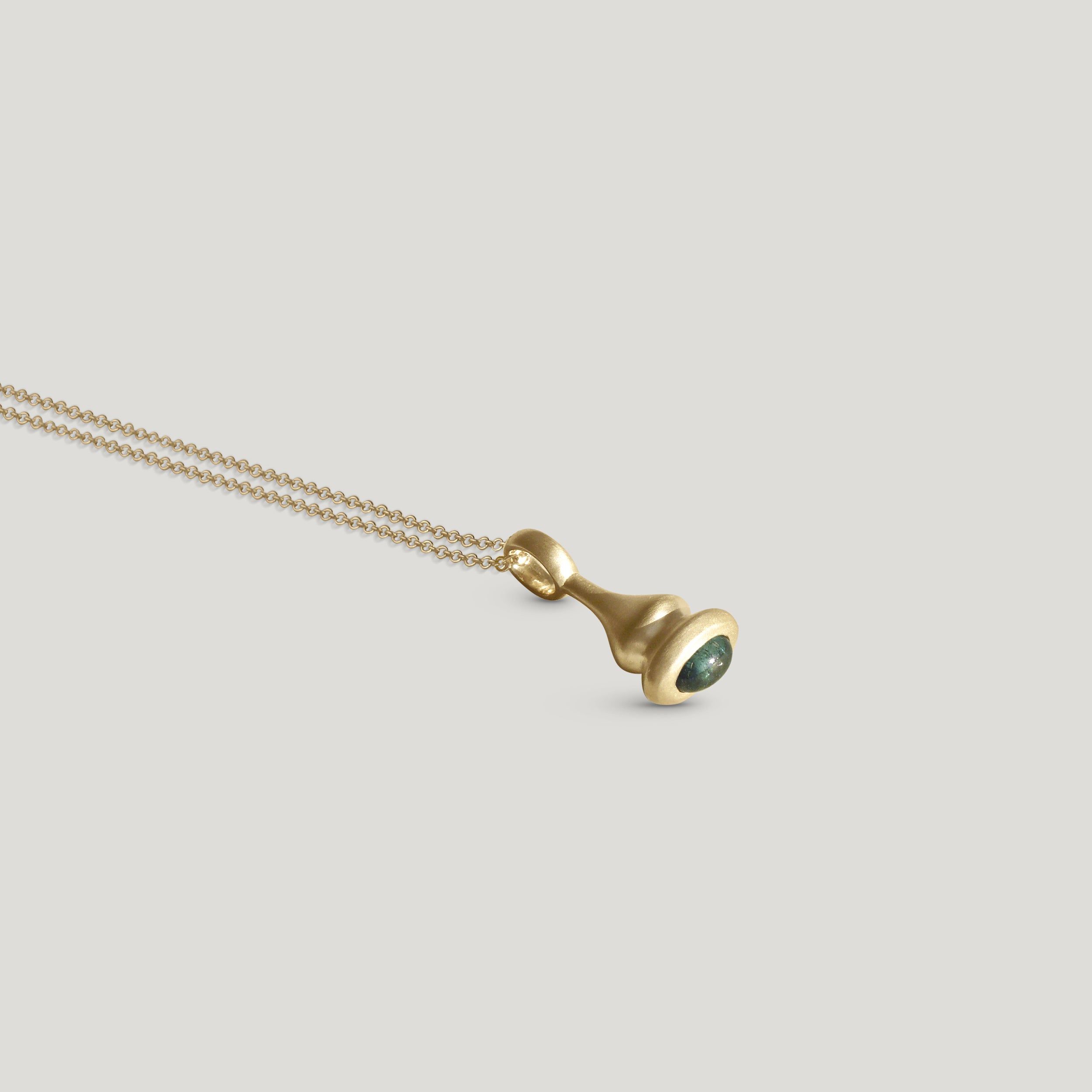 Teal tourmaline pendulum charm no. 6 on neutral background